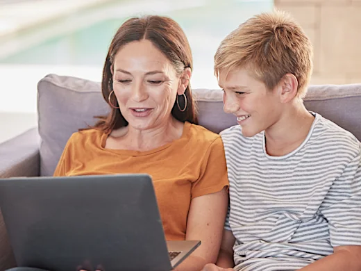 Mutter und Sohn sehen sich eine Schulhomepage am Laptop an